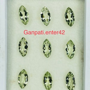 May include: Eight marquise-shaped green gemstones displayed in a white box. The gemstones are arranged in three rows of two. The text "Ganpati.enter42" is printed in red on the box.