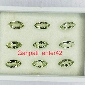 May include: Eight marquise-shaped green gemstones displayed in a white box. The gemstones are arranged in two rows of four. The text "Ganpati.enter42" is printed in red on the bottom of the box.
