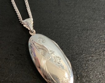 Silver locket with a bird design on chain