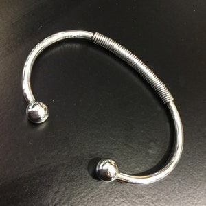 Silver torque bangle with a wire wrap centre