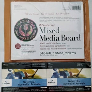 May include: A package of Strathmore Mixed Media Board and two packages of Canson Montval Watercolor paper. The Strathmore board is 8 x 10 inches, and the Canson paper is 4 x 6 inches. The packaging is white and black.