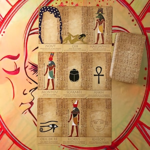 Peut inclure: Un jeu de cartes de tarot sur le thème égyptien, avec des illustrations de divinités et de symboles. Les cartes présentent du texte hiéroglyphique et sont de couleurs marron et beige. Un carnet au design assorti est également présent.
