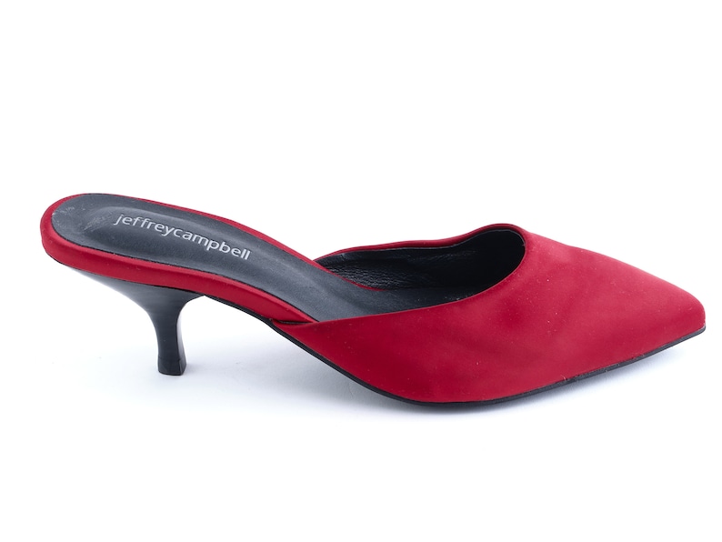 May include: Red satin heeled mule with a pointed toe and a low heel. The shoe has a black insole with the text "jeffreycampbell" printed on it.