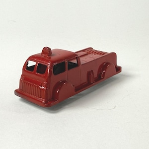 May include: A vintage red toy fire truck. The toy truck features a cab with windows, a ladder rack, and rounded wheels. The fire truck is painted in a solid red color and appears to be made of metal.