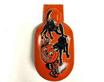 May include: Vintage Halloween decoration featuring a smiling jack-o'-lantern and two black cats on an orange background. The metal decoration has a rectangular top and a rounded bottom, perfect for seasonal decor.
