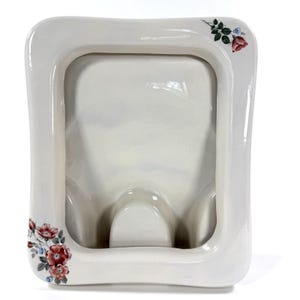 May include: A white ceramic mug with a black handle and the text "But First, Coffee" in a black, handwritten-style font. The mug is on a white surface.