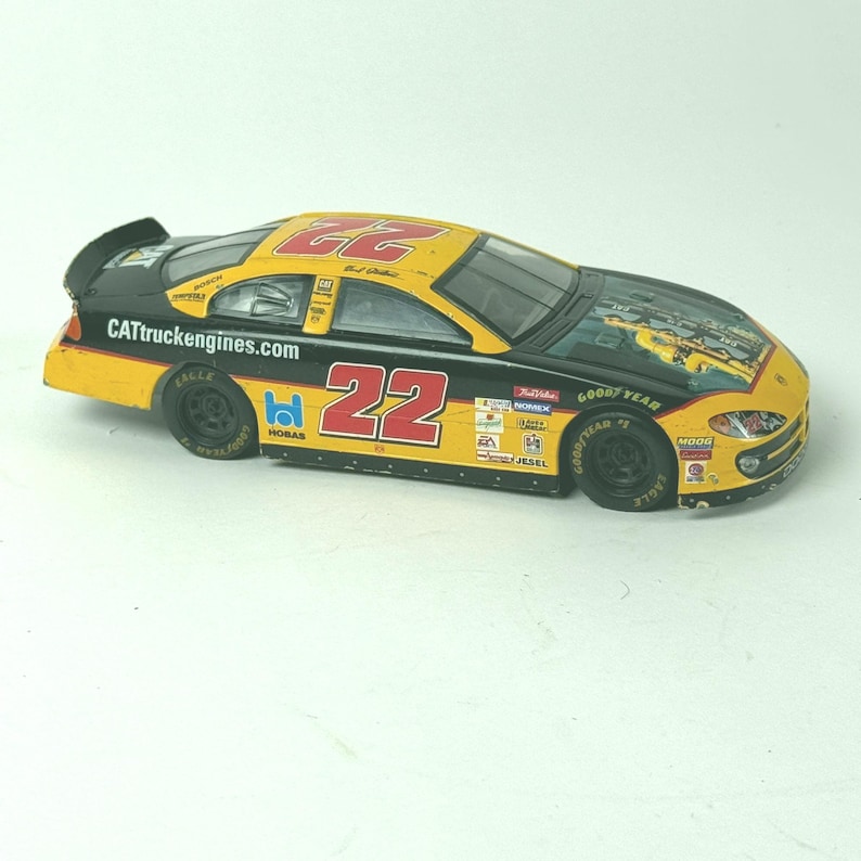 May include: A toy race car with a black and yellow design. The number "22" is prominently displayed on the sides and roof. The car features sponsor logos and the text "CATtruckengines.com".