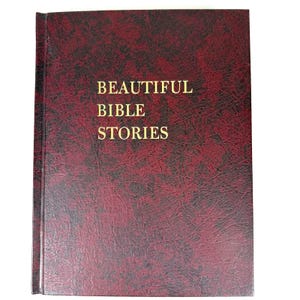 May include: A hardcover book with a burgundy cover featuring the gold text "BEAUTIFUL BIBLE STORIES." The cover has a textured, leather-like appearance. The book is closed and upright.