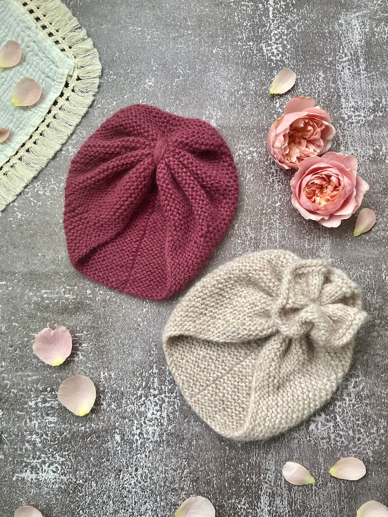 K&ouml;nnte beinhalten: Zwei Strickb&auml;nder in verschiedenen Farben. Eines ist in einem staubigen Rosaton und das andere in einem hellen Beige. Beide Stirnb&auml;nder sind mit einer einfachen Strickmasche gearbeitet und haben oben einen Knoten.