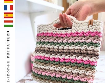 May include: A handmade crochet tote bag with a striped pattern in cream, pink, brown, and green. The bag has a rectangular shape with a handle and a small leather tag. The text "PDF PATTERN" is visible on the side.