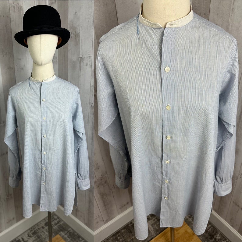Pu&ograve; includere: Una camicia a maniche lunghe a righe blu chiaro con colletto alla coreana e chiusura con bottoni. La camicia ha un bordo bianco intorno al colletto.