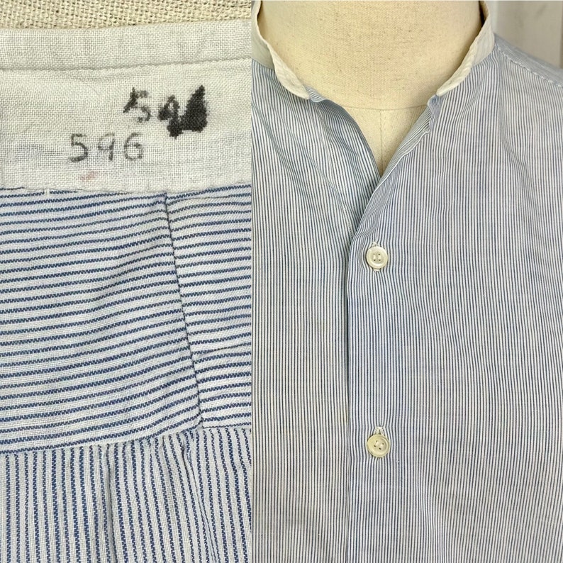 Pu&ograve; includere: Una camicia di cotone a righe blu e bianche con colletto alla coreana e chiusura con bottoni. La camicia ha un'etichetta con i numeri "544" e "596".