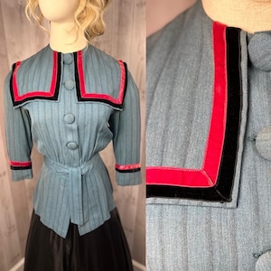 May include: A blue, striped, vintage blouse with a sailor collar. The collar is trimmed with black and red velvet ribbon. The blouse has a fitted waist and long sleeves with cuffs.