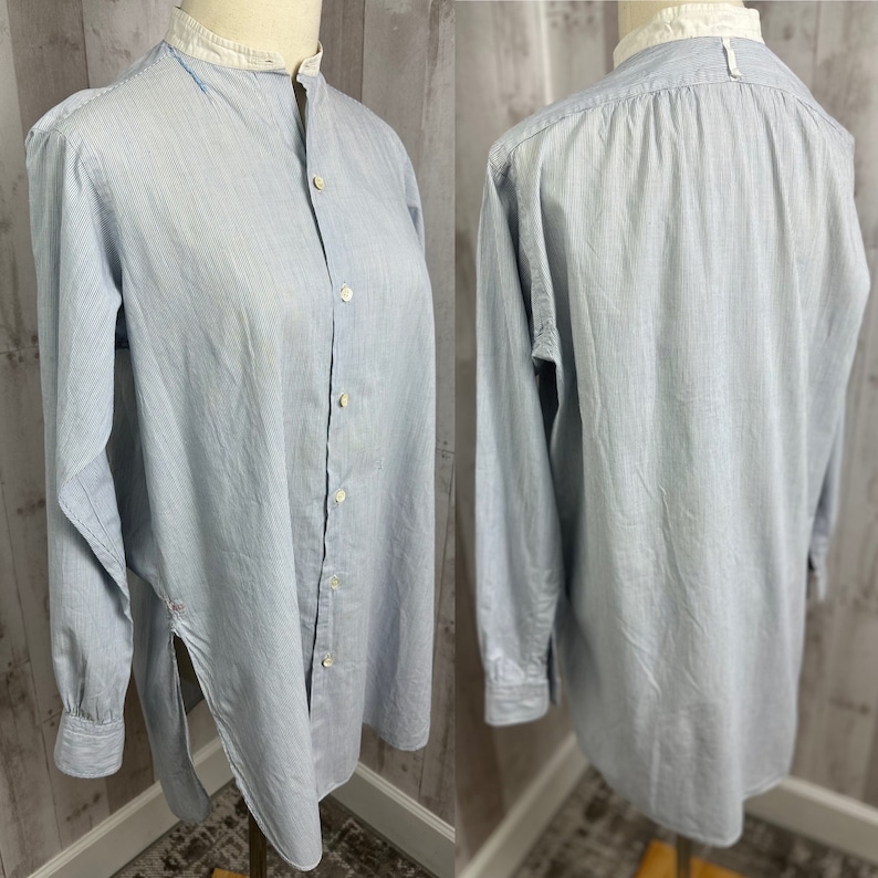 Pu&ograve; includere: Una camicia a maniche lunghe blu chiaro con colletto bianco e chiusura con bottoni sul davanti. La camicia ha un motivo a righe e una lunghezza leggermente pi&ugrave; lunga.