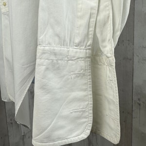 Pu&ograve; includere: Camicia bianca a maniche lunghe con polsini abbottonati. La camicia &egrave; realizzata in un tessuto leggero e ha una vestibilit&agrave; classica e aderente.