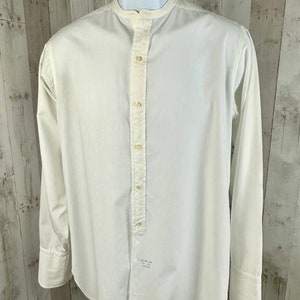 Pu&ograve; includere: Una camicia bianca a maniche lunghe con bottoni, colletto alla coreana e una singola patta con bottoni. La camicia ha una vestibilit&agrave; rilassata ed &egrave; realizzata in un tessuto leggero.
