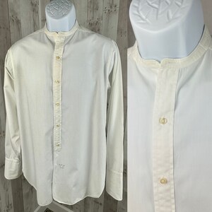 Pu&ograve; includere: Una camicia bianca a maniche lunghe con bottoni, colletto alla coreana e una singola patta con bottoni. La camicia ha un tessuto leggermente strutturato ed &egrave; realizzata in cotone.