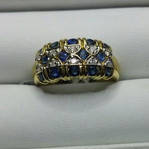May include: A gold band ring with a design of alternating blue sapphires and white diamonds.