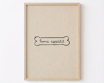 May include: A framed wall art print featuring a light beige textured background. In the center, a black hand-drawn outline of a dog bone contains the handwritten black text "bone appétit" centered within the shape of the bone.