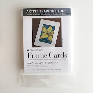 May include: A package of Strathmore Frame Cards with a white die-cut window. The package includes 6 cards and envelopes, each measuring 3.5" x 4.75". The packaging features the text "Artist Trading Cards" and "Frame Cards".