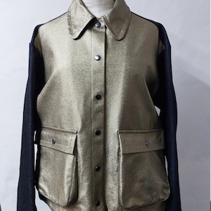 May include: A gold metallic jacket with black sleeves and a button-up front. The jacket has two large pockets on the front.