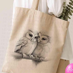 May include: A beige canvas tote bag featuring a detailed charcoal-style illustration of two owls perched together on a branch. The bag has two shoulder straps and includes a circular graphic with the text Personalise Me in the upper left corner.