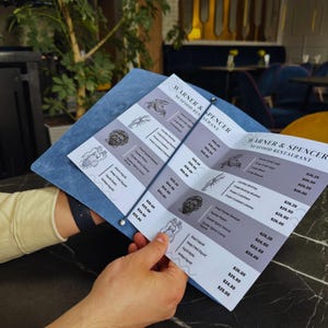 May include: A close-up of a menu from Warner & Spencer Seafood Restaurant. The menu lists various seafood dishes with prices, including Snow Crab Legs, Jumbo Shrimp, Fried Shrimp Basket, Fresh Cooked Lobster, and Grilled Squid.