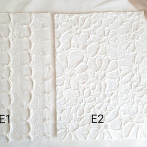 Puede incluir: Dos muestras de tela blanca texturizada, una con un patrón ondulado etiquetado como "E1" y la otra con un patrón floral etiquetado como "E2".