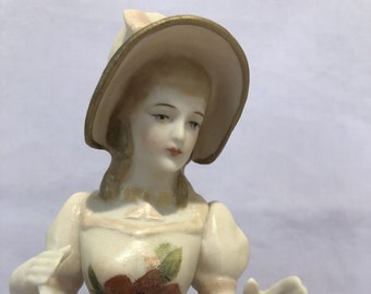 Half doll "Juliette with bonnet" approx 10 cms tall painted in cream with pink trim and decals.