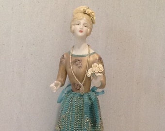 Half doll "Lillianne" painted in gold with decals and trimmed in turquoise.  Blonde hair with white hand made porcelain roses.