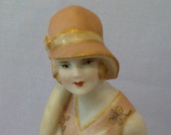 Antique reproduction half doll "Kylie" painted in deep gold with cream trim. Her hair is blonde and eyes brown.