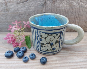 Handmade and hand painted beige dark spotted stoneware mug Blue roses
