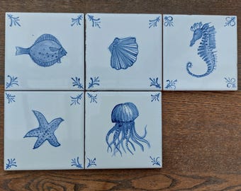 The hand painted set of 5 blue ad white backsplash tiles of sea creatures. Wall art, bathroom, shower kitchen, living room, fire place.