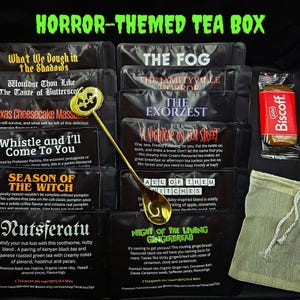 Könnte beinhalten: Eine Horror-Themen-Teebox mit verschiedenen Teemischungen, darunter "The Fog" und "Night of the Living Gingerbread". Ein goldfarbener Löffel mit Kürbisgesicht liegt auf den Teepäckchen. Ein Biscoff-Keks und ein kleiner Beutel mit Kordelzug sind ebenfalls zu sehen.