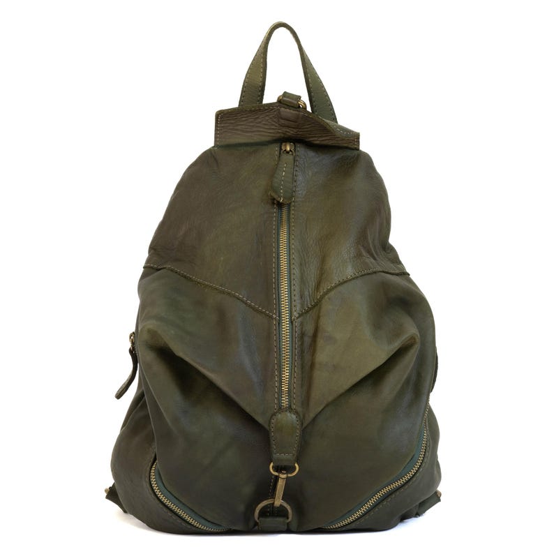 May include: An olive green leather backpack featuring a vertical centre zip, a top handle, and two additional zipped compartments at the base. The bag has a soft, slouchy structure with antique brass-toned metal hardware and zip pulls.