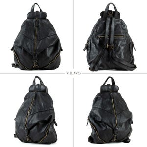 May include: A black leather backpack featuring a prominent vertical front zip, a top handle, and adjustable shoulder straps. The design includes multiple zipped compartments, antique brass-toned hardware, and a textured, soft-structured finish.