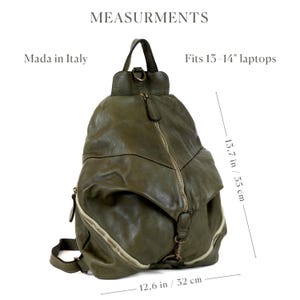 May include: An olive green leather backpack with a central vertical zip, a top handle, and adjustable straps. Text reads: MEASURMENTS, Mada in Italy, Fits 13-14" laptops, 13.7 in / 35 cm, and 12.6 in / 32 cm. The bag features a slouchy, soft-structured design.