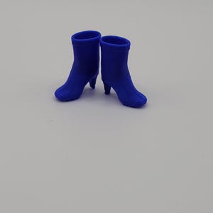 Puede incluir: Un par de botines azul cobalto con tacones peque&ntilde;os. Los botines tienen un acabado liso y mate y una silueta cl&aacute;sica. Los tacones miden aproximadamente 5 cm de alto.