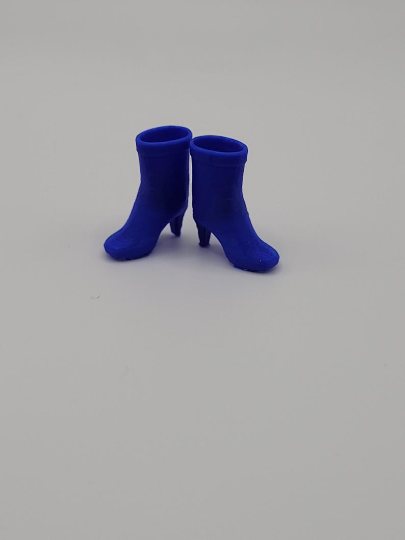 Puede incluir: Un par de botines azul cobalto con tacones peque&ntilde;os. Los botines tienen un acabado liso y mate y una silueta cl&aacute;sica. Los tacones miden aproximadamente 5 cm de alto.