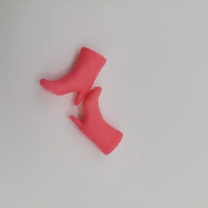 Puede incluir: Dos botines rosas brillantes con tacones de aguja se muestran sobre un fondo blanco. Los botines tienen un acabado liso y mate y una silueta cl&aacute;sica. Los tacones son delgados y puntiagudos.