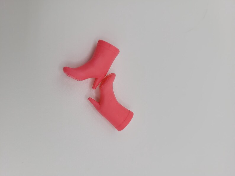 Puede incluir: Dos botines rosas brillantes con tacones de aguja se muestran sobre un fondo blanco. Los botines tienen un acabado liso y mate y una silueta cl&aacute;sica. Los tacones son delgados y puntiagudos.