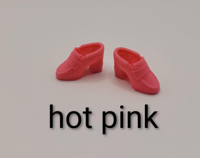 May include: A pair of miniature hot pink loafers with a block heel and a classic penny loafer strap across the vamp. The shoes are moulded from a solid, smooth material and feature a rounded toe design. The text hot pink is printed below.