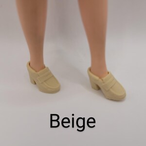 May include: A pair of beige slip-on loafers with a block heel. The shoes feature a classic penny loafer strap across the top and a rounded toe design. The word Beige is printed in black text below the shoes on a plain white background.