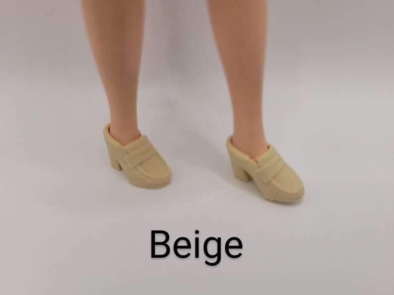 May include: A pair of beige slip-on loafers with a block heel. The shoes feature a classic penny loafer strap across the top and a rounded toe design. The word Beige is printed in black text below the shoes on a plain white background.