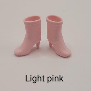 Puede incluir: Un par de botines rosa claro con tacones peque&ntilde;os. Las botas est&aacute;n hechas de un material liso y tienen un dise&ntilde;o simple y cl&aacute;sico. El texto "Light pink" est&aacute; debajo.