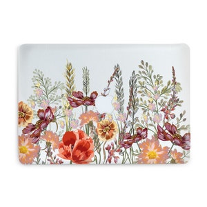 May include: A laptop skin with a floral design featuring red, orange, and pink flowers with green leaves and stems on a light blue background.