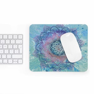 May include: A blue and purple mandala design mouse pad with a white computer mouse on top. The background is a light blue watercolor wash.