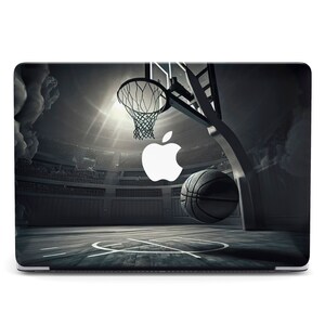 May include: A black and white laptop skin with a basketball hoop and a basketball in the air. The Apple logo is in the background.