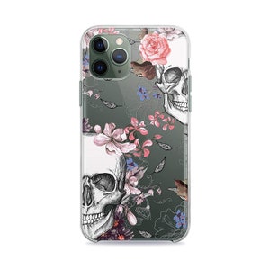 May include: Clear phone case with a floral and skull design. The case features pink, white, and blue flowers, and two black and white skulls. The case is designed for an iPhone.