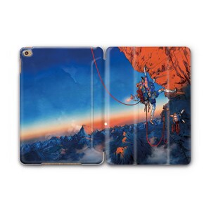 May include: An open tablet case featuring a mountain climbing scene. The left side displays a blue sky with mountains, while the right side shows a climber on a red rock face. A red rope connects the climber to the top.